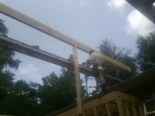 Carpenter setting a ridge beam over a new addition frame — Ice Dam Removal by Roofing Brothers in Felt