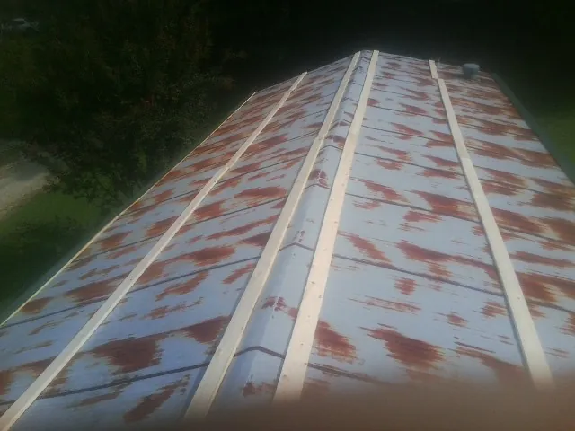 Rusted metal roof panels with new wood purlins before replacement — Storm Damage Roof Repair in Felt by Roofing Brothers