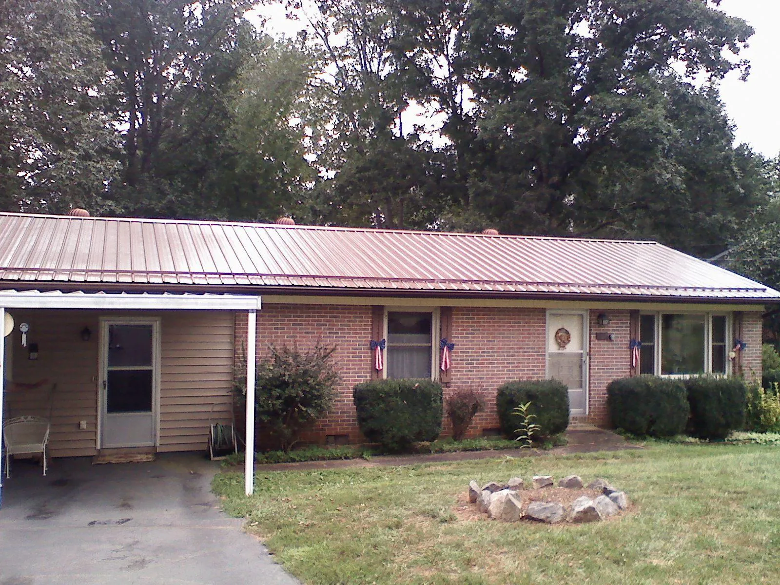 Bronze metal roof and carport on a brick ranch home — Roof Repair work by our crew in Felt